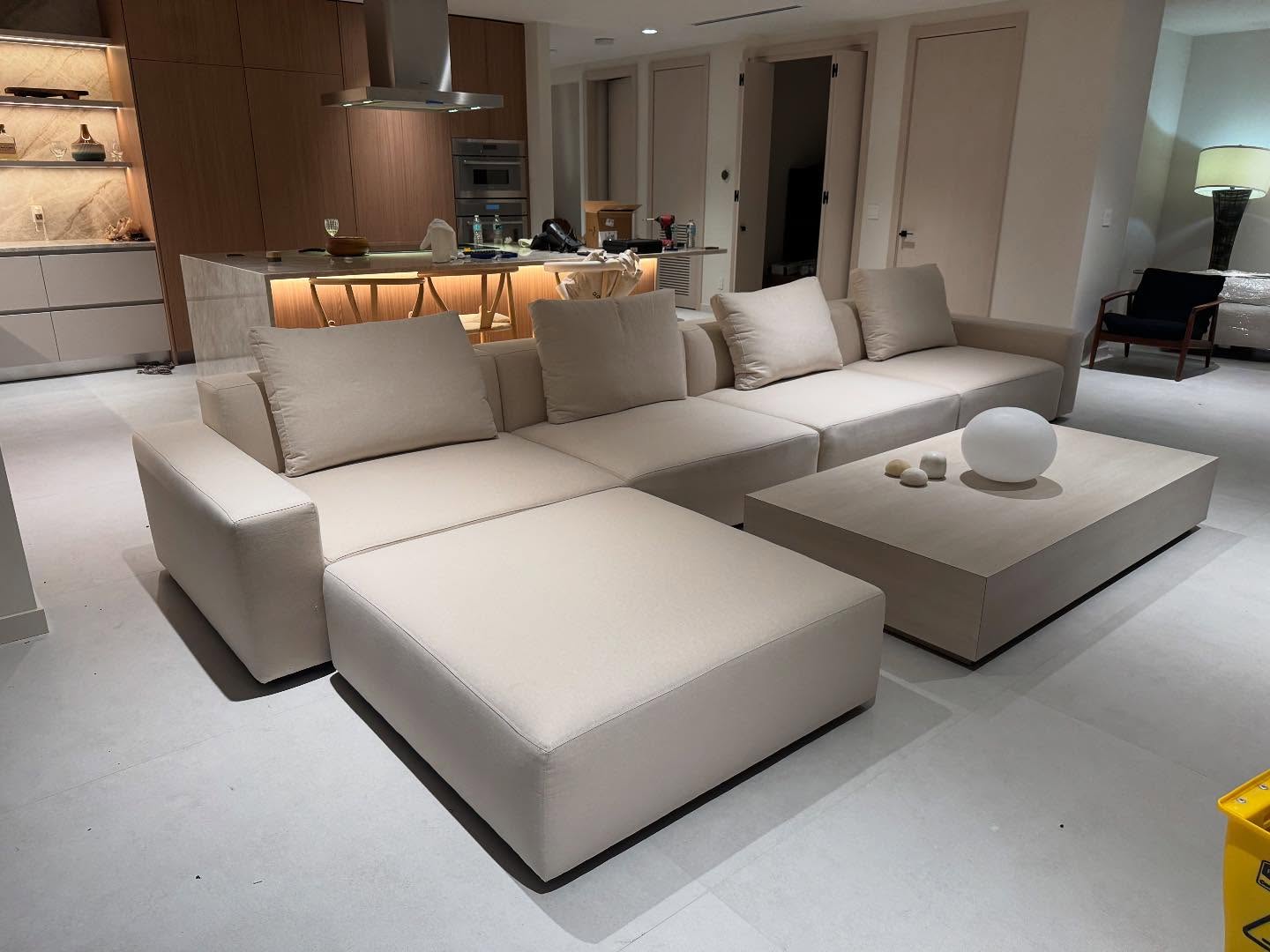 A large bisque linen sectional with a chaise, in an open kitchen and living room.